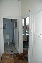 <p>Gang in de richting van de achtergevel. Het toilet aan het eind van de gang was oorspronkelijk een stuk ondieper, zoals blijkt uit de aansluiting van de deurkozijnen en het oorspronkelijke tegelwerk dat deels bewaard bleef. </p>
